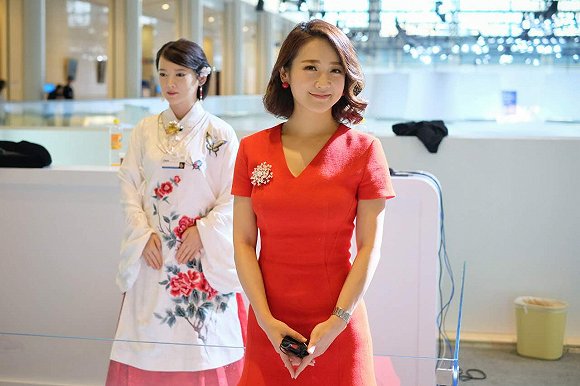 人形機器人“佳佳”(左)與雙語主持人、艾問傳媒創始人艾誠(右)